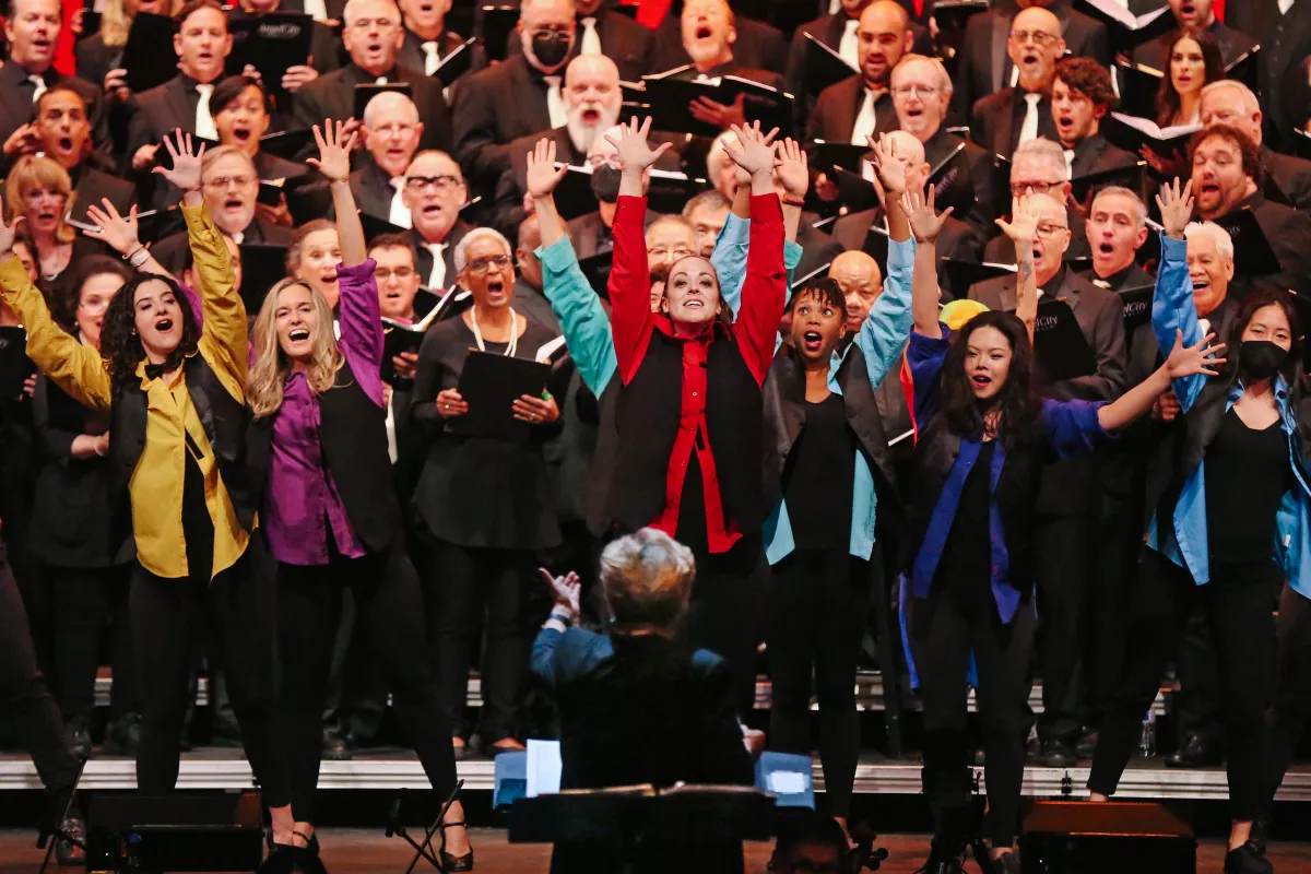  Conductor Sue Fink, foreground (back turned), leads the Angel City Chorale in rehearsal before a performance at UCLA’s Royce Hall on June 11. (Genaro Molina / Los Angeles Times)